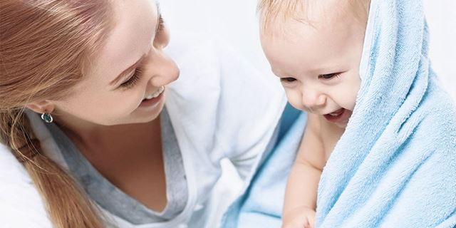 Mother with baby wrapped in towel