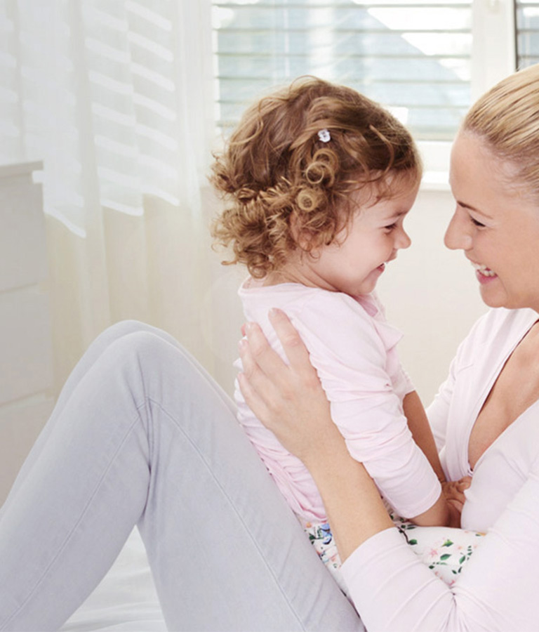 Mutter und Tochter kuscheln im Bett